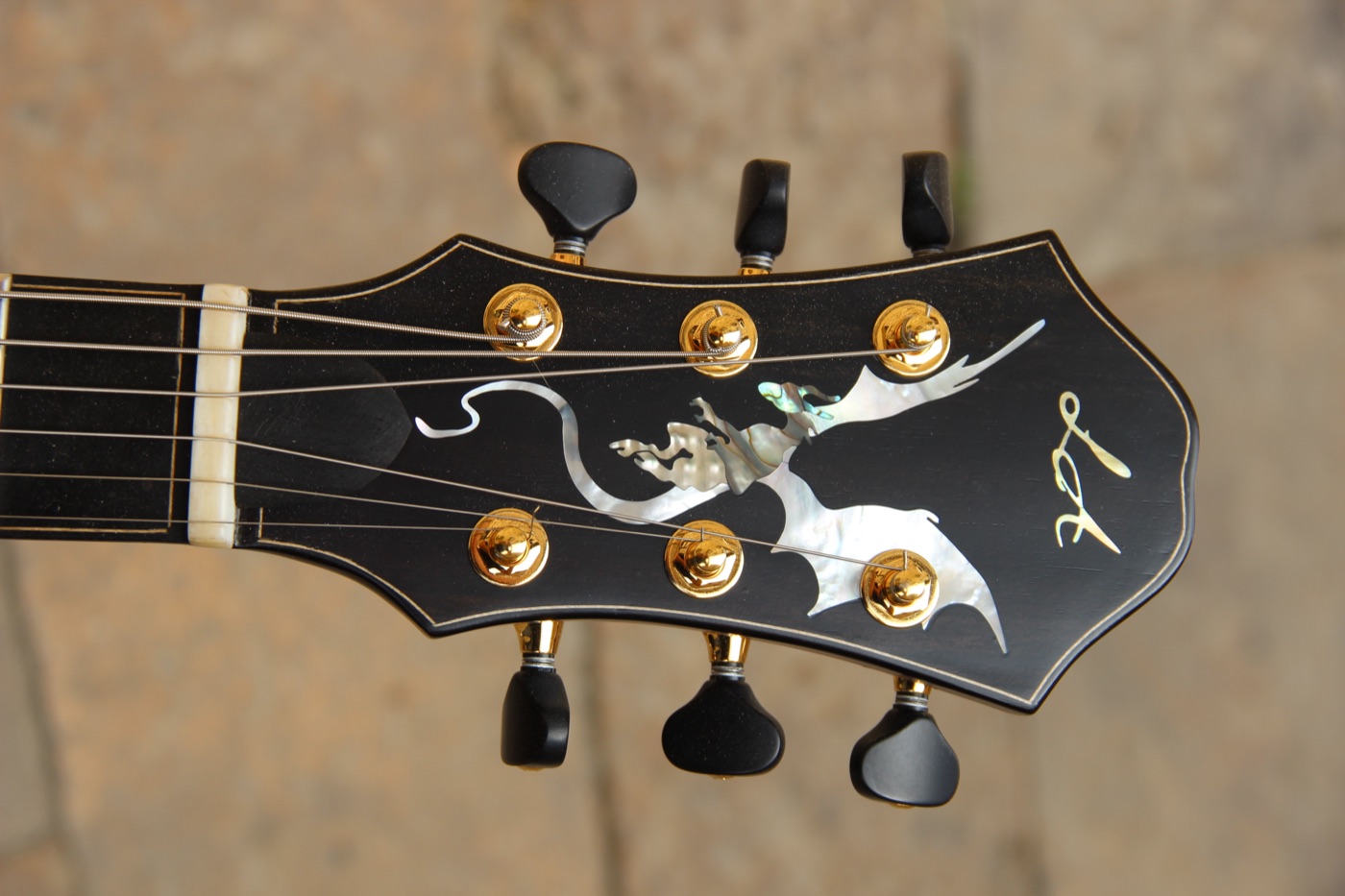 Mother-of-pearl dragon inlay on a guitar headstock